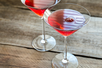Two cosmopolitan cocktails on the wooden background - obrazy, fototapety, plakaty