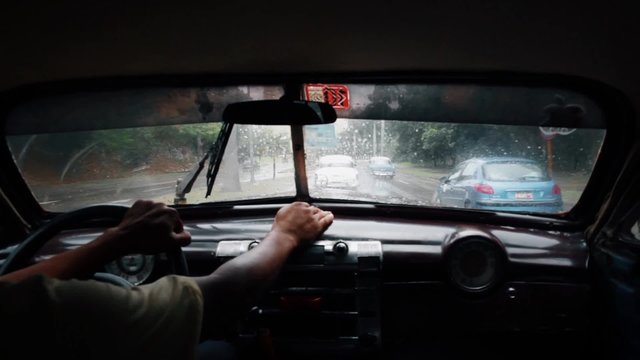 Driving in an old vintage taxi car in La havana road in Cuba