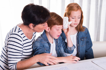 Fototapeta premium Mother and sister are comforting little boy