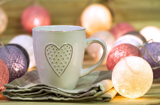 Cup with heart in a warm atmosphere with lights