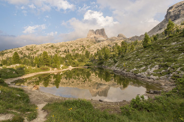 Fascinating reflections of the Dolomites mountains in lake Limedes at Sunset. Vivid and bright colors of the dramatic evening.