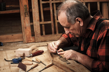 Close-up of senior carpenter restoring old furniture