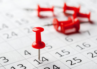 Concept image of a calendar with red push pins