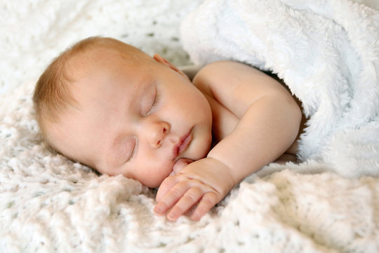 Sweet Newborn Infant Girl Sleeping in White Blankets