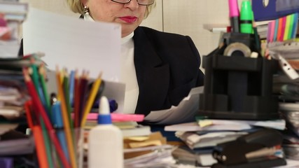 Woman as an administration economist in glasses tears commercial papers