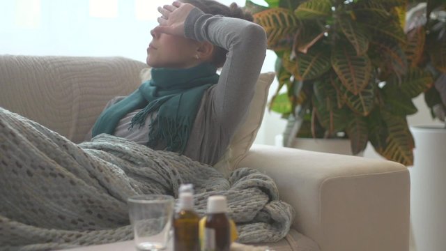Sick woman lying on her sofa at home. Flu