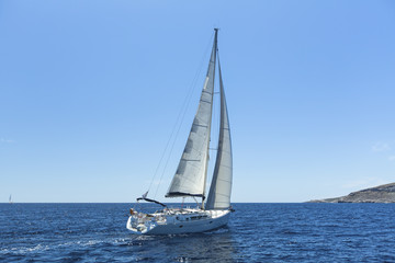 Sailing in the wind through the waves at the Aegean Sea. Luxury yachts.