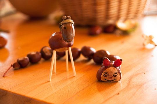 creative handmade toys made of chestnuts and acorn on the wooden table