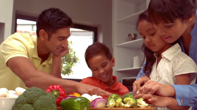 Smiling Hispanic family are cooking together