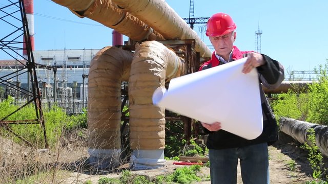 Maintenance engineer with project drawing at heat electropower station