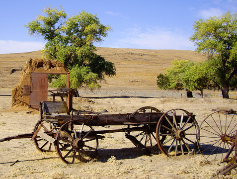 An old west buckboard wagon in a field.