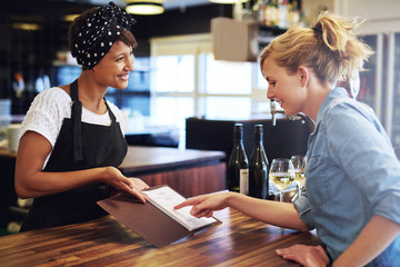 Female customer choosing wine in a bar