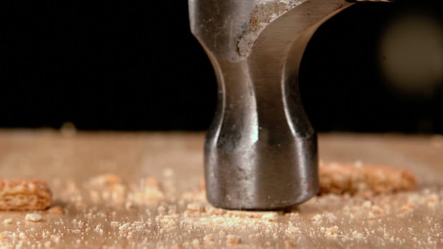 Hammer smashing biscuits on table