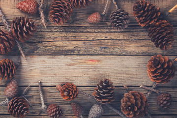 Old wooden background with pine cones. Yuletide decoration.Toned image. Vintage style. Copy space. selective focus.