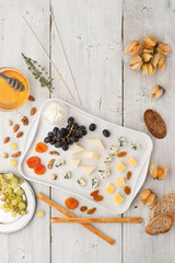 Cheese platter with different fruits ,nuts  and honey top view