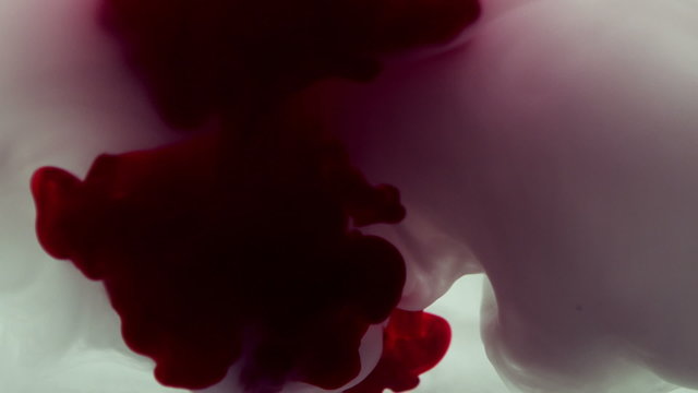 Red And Purple Ink Swirling In Water