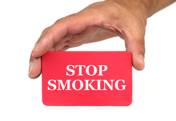 Hand holding and showing a red card with " STOP SMOKING " text