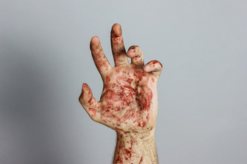 blutige hand vor grauem Hintergrund