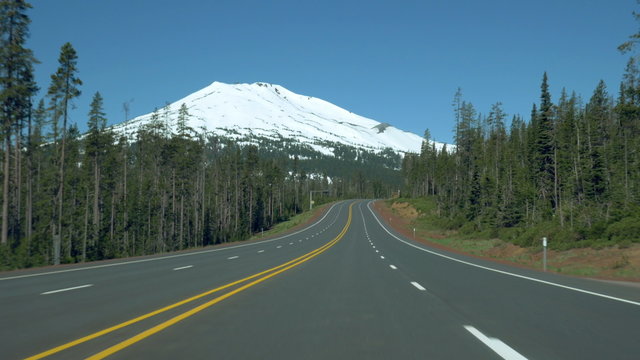 Driving POV on the Cascade Lakes Scenic Byway, approaching Mt. Bachelor, near Bend, Oregon.