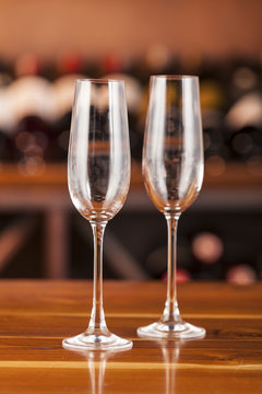 two empty glasses in background with bottles of wine
