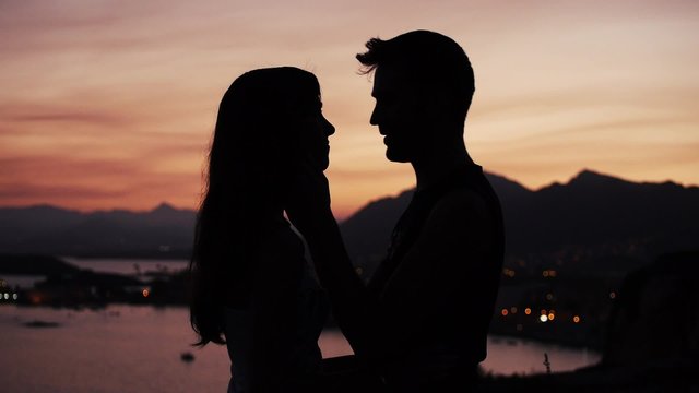 pareja bes&aacute;ndose en puesta de sol paisaje costero puerto de Mazarr&oacute;n Murcia Espa&ntilde;a