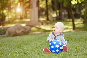 Happy baby sitting in the green grass