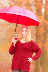 Fashion woman with umbrella relaxing in fall park.