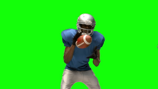 Serious american football player tackling for ball 