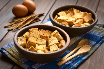 Bread pudding made of diced stale bread, milk, egg, cinnamon, sugar and butter, photographed with natural light (Selective Focus, Focus one third into the first bread pudding)