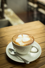 Hot latte art coffee cup on table, vintage and retro style.