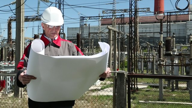 Station technical director with working drawings at nuclear power station