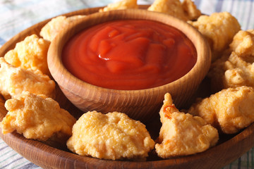 crispy popcorn chicken fillet with sauce macro on a plate. horizontal
