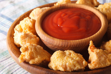crispy popcorn chicken fillet with sauce closeup on a plate. horizontal
