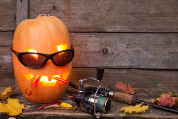 halloween pumpkin in eyeglass with fishing tackles