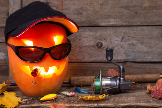halloween pumpkin in hat with fishing tackles