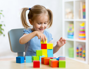 child toddler playing wooden toys at home