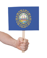 Hand holding small card - Flag of New Hampshire