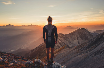 Male hiker observing the sunset at the top of the local big mountain. The photograph was taken in Karavanke mountain range in Slovenia. - obrazy, fototapety, plakaty