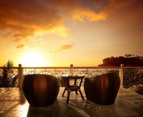 Terrace lounge with rattan armchairs and seaview in a luxury resort