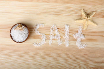 the inscription sea salt on a plate and starfish on wooden background