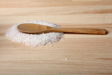 sea salt and wooden spoon on wooden background