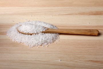 Fototapeta na wymiar sea salt and wooden spoon on wooden background