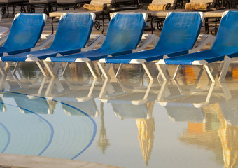 Fototapeta premium Empty beach chairs near pool