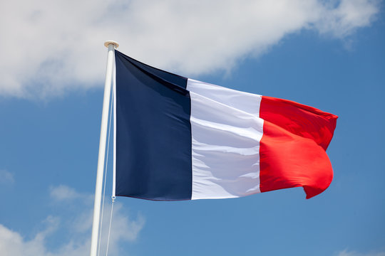 French flag against blue cloudy sky