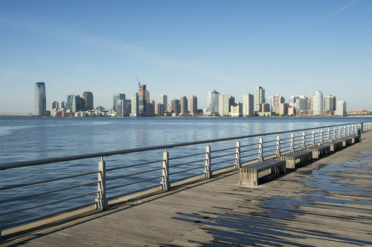 City skyline of Jersey City and Hoboken New Jersey from a pier  in New York City across the waters of the Hudson River