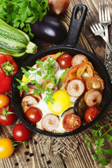 Fried eggs with vegetables and sausage