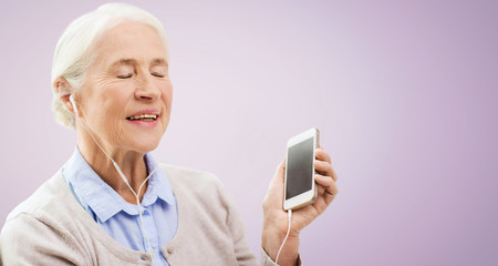 senior woman with smartphone and earphones