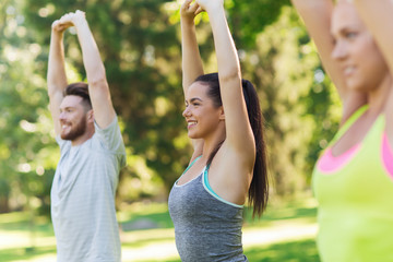 Obraz premium group of friends or sportsmen exercising outdoors