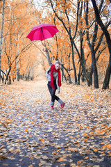 танцующая девушка в осеннем парке, с красным зонтом