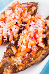 fried bangus or milkfish topped with fresh sliced onions and tomatoes